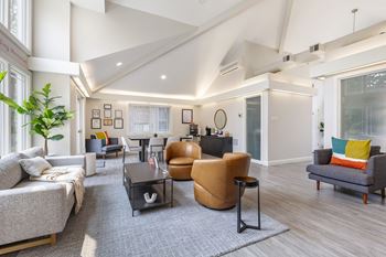 A living room with a grey couch, a brown chair, and a black coffee table.